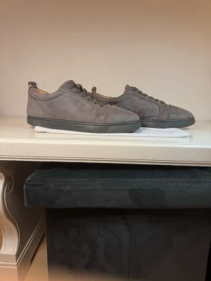 Gråa sneakers från Christian Louboutin - Snygga loubs i mocka imitation. Skorna är i bra skick perfekt till våren.                                                             Tveka inte på att höra av dig vid frågor eller funderingar. Pris kan diskuteras vid snabb affär.