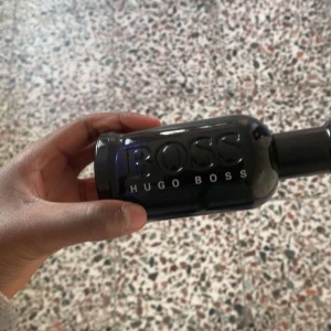 Svart parfymflaska från Hugo Boss - Säljer en stilren parfym från Hugo Boss i en svart, blank flaska med tydlig logga. Flaskan har en rundad form och känns lyxig och modern – perfekt för dig som gillar klassiska dofter med en twist.
