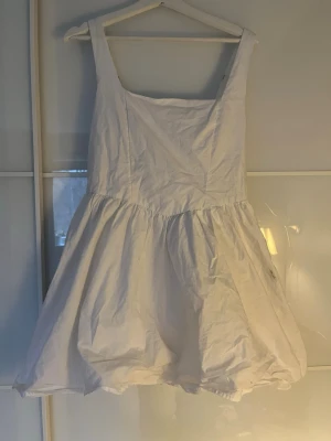 Vit sommarklänning  - Jag säljer min fina vita sommarklänning från Gina tricot, den är i storlek 42 men jag säljer den eftersom att den är väldigt kort på mig som är 173 cm lång, jag skulle också säga att den skulle kunna passa någon som är storlek 38-40 också. Den är perfekt till midsommar eller student men går även att klä ner. Den har en fläck på sidan som inte går bort men den märks knappt av. Den har även fickor och justerbara band. 