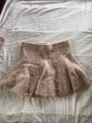 Mohair blandad kjol  - Supersöt beige kjol från H&M Edition i fluffigt material med utsvängd form i mohair blandning. Använd fåtal gånger väldigt fint skick 
