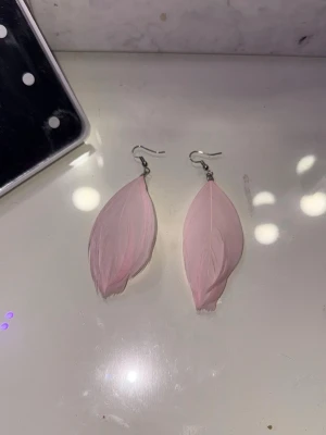 Två par unika örhängen, fjäder & flaska - Säljer Olika par coola örhängen! Ett par med ljusrosa fjädrar, och ett par med små boba flaskor, ett par jordgubbar, och ett par örhängen med drakfrukt.