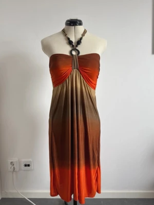 halterneckklänning / axelbandslösklänning - Säljer en somrig axelbandslösklänning med ombre-effekt i orange och bruna nyanser. Går även att använda som en halterneckklänning enligt bilderna! ❤️