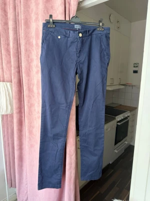 Tommy Hilfiger chinos – mörkblå – storlek 34/36 (se mått) – nyskick - Tommy Hilfiger chinos – mörkblå – storlek 34/36 (se mått) – nyskick  Klassiska chinos från Tommy Hilfiger i mörkblå färg. Stilren modell med stretch för bra passform och komfort. Passar både till vardag och mer uppklätt. Oanvända i mycket fint skick.  • Märke: Tommy Hilfiger • Modell: chinos • Färg: mörkblå • Material: 98% bomull, 2% elastan • Stretchiga och bekväma • Sidofickor och bakfickor • Skick: nya / nyskick
