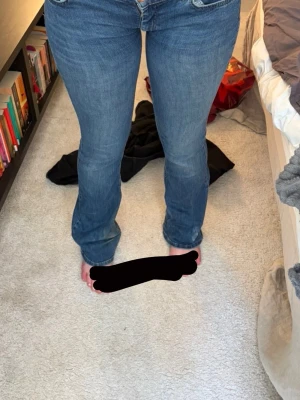 Blå bootcut jeans med stretch - Säljer ett par klassiska blå bootcut jeans med stretch. Jeansen har låg midja och snygga sömmar. Perfekta för dig som gillar en tidlös look och vill ha ett par jeans som sitter skönt och formar sig efter kroppen. Det står storlek 32 i byxorna men passar mig bra som är 170 och skulle mer säga att storleken är 36-S istället men de sitter som sagt skönt och stretchigt men formar sig mycket också.