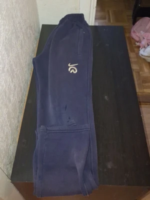 Mörkblå Nike mjukisbyxor - Mörkblå mjukisbyxor från Nike med broderad logga i vitt på ena benet. Byxorna har resår i midjan och sidofickor. Perfekta för chill dagar eller träning. Tillverkade i mjukt material för maximal komfort.