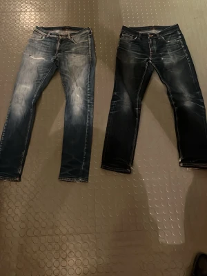 Två par blå jeans från Nudie Jeans - Säljer två par snygga blå jeans från Nudie Jeans. De mörkblå jeansen är selvedge jeans och av modellen Gritty Jackson storlek 31/32. De ljusblå jeansen är av modellen Lean Dean storlek 31/34. Jeansen säljs tillsammans till ett paketpris. Skriv gärna om du har frågor eller vill ha fler bilder!  
