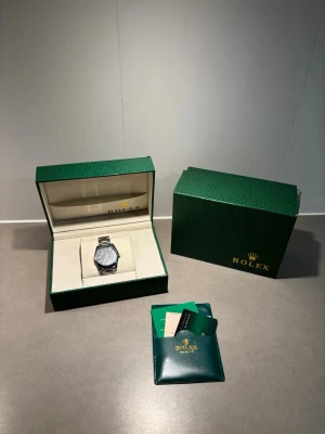  silverfärgad klocka i stål - Snygg och klassisk klocka i silverfärgat stål med länkarmband. Klockan har en rund urtavla och stilren design, levereras i originalbox med certifikat och tillbehör. Perfekt för dig som vill ha en tidlös accessoar från ett ikoniskt märke.