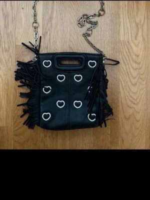 Svart axelväska med pärlhjärtan - Säljer en svart maje väska med fransar, säljer för att den inte längre kommer till nögon användning