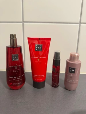 Rituals kroppsvårdsset Ayurveda & Sakura - Fyra produkter från Rituals: två röda Ayurveda (dry oil, body cream), en röd ansiktsspray och en rosa Sakura duschkräm. Produkterna har eleganta förpackningar i rött och rosa med svarta detaljer. Perfekt för dig som gillar lyxig kroppsvård och doft. Shower gel till höger är helt full och krämen i mitten är nästan helt full