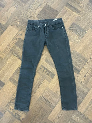 Dondup George mörkgrå/svart - Säljer nu ett par riktigt snygga Dondup George som jag tyvärr vuxit ur i storlek w32. Perfekta för dig som vill ha ett par schysstare jeans till allt från klubben till skolan. Kan mötas i Stockholm eller frakta!💯