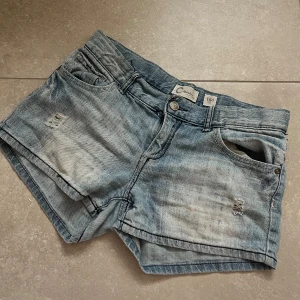 STOCKHOLMSTIL MINI JEANSSHORTS - Säljer mina såå snygga lågmidjade mini jeansshorts i vintage modell. De är i storlek 164 vilket passar mig med storlek 34/36. En ”washed” blå färg med snygga bakfickor och slit/hål detaljer. Finns inte att köpa längre! Pris kan diskuteras. 