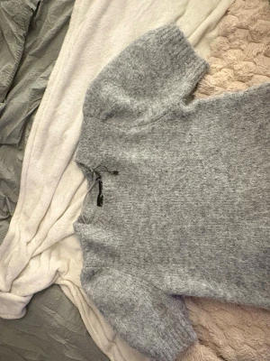 Grå fluffig stickad kort armad tröja  - Gullig ljusgrå fluffig stickad kortarmad tröja från vermoda i storlek M