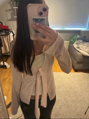 Ljusrosa topp med knyt - ljusrosa topp med knyt framtill och långa ärmar. köpt på Gina Tricot i stolek XS. bra passform och passa perfekt nu till sommaren💓