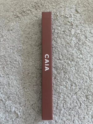 Oöppnad CAIA Läppenna Caramel Cutie - Snygg läppenna från CAIA i nyansen Caramel Cutie. Pennan har en varm karamellbrun ton och kommer i en stilren förpackning. Perfekt för att definiera och framhäva läpparna med en naturlig look. Nypris: 195kr!