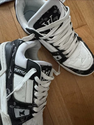  vita och svarta sneakers - Säljer ett par sneakers i vitt och svart. Skorna har vita skosnören, svart och vit ovandel i läder  Snygg och modern design som sticker ut.