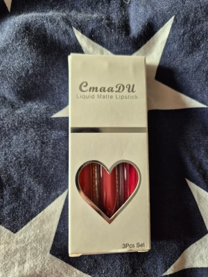 CmaaDU Liquid Matte Läppstift 3-pack - Säljer ett set med tre flytande matta läppstift från CmaaDU. Färgerna är orange, brun och röd. Läppstiften kommer i smidiga tuber med vita lock och transparent hylsa så du ser färgen direkt. Perfekt för dig som gillar att variera din look med olika nyanser.