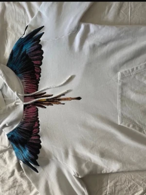 Vit marcelo burlon hoodie - Säljer en vit hoodie från Marcelo Burlon. Den är i helt nytt skick och använd ca 1 gång så inga defekter eller skavanker. Storlek M