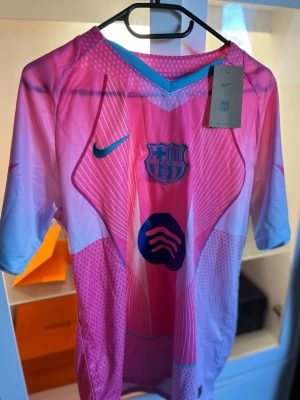 Barça rosa matchtröja Nike M - Snygg FC Barcelona matchtröja från Nike i rosa och ljusblått med klubbmärke och sponsorlogga på bröstet. Tillverkad i lätt och ventilerande Dri-FIT material, perfekt för träning eller match. Kortärmad och modern design.
