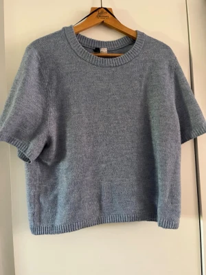 Ljusblå stickad t-shirt - Ljusblå stickad t-shirt. Använt en del. Lite nopprig därav det låga priset. Utöver det inga fläckar eller liknande. Säljer även på vinted så först till kvarn.