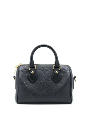 svart handväska i läder - Snygg svart handväska i präglat läder med klassiskt monogrammönster. Väskan har guldfärgade metalldetaljer, dubbla handtag och dragkedja upptill. Perfekt accessoar för att lyfta din outfit.