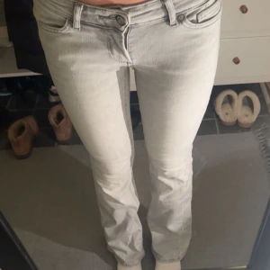 Ljusgrå jeans från ONLY - Snygga ljusgrå jeans från ONLY med klassisk femficksdesign och bootcut. Jeansen har låg midja och är tillverkade i mjukt denim-material med en lätt tvättad look. Passar perfekt för dig som gillar stilrena och enkla jeans med en modern touch. Loggan har lossnat lite. (Jag är 165 cm)