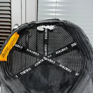 Svart truckerkeps från Corteiz - Svart truckerkeps från Corteiz med vit broderad grafik framtill som visar stjärnor och en båt. Kepsen har mesh på sidorna och bak, samt justerbar snapback. Snygg detalj med Corteiz-logga på insidan och sidan av kepsen.