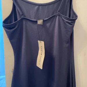 Mörkblå enkel klänning från SHEIN - Mörkblå, ärmlös klänning från SHEIN BASICS med linneform. Klänningen är kort men stretchig så kan bli längre. Den är helt ny med prislapp