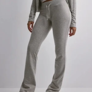 Grå mjukisbyxor med snörning - Säljer ett par ljusgrå mjukisbyxor med bred resår i midjan och snörning framtill. Byxorna har raka ben och är tillverkade i mjukt bomullsmaterial, perfekta för en chill och avslappnad stil. Dem är uppsydda så det passar en med 73cm i innerbens längd👌🏼