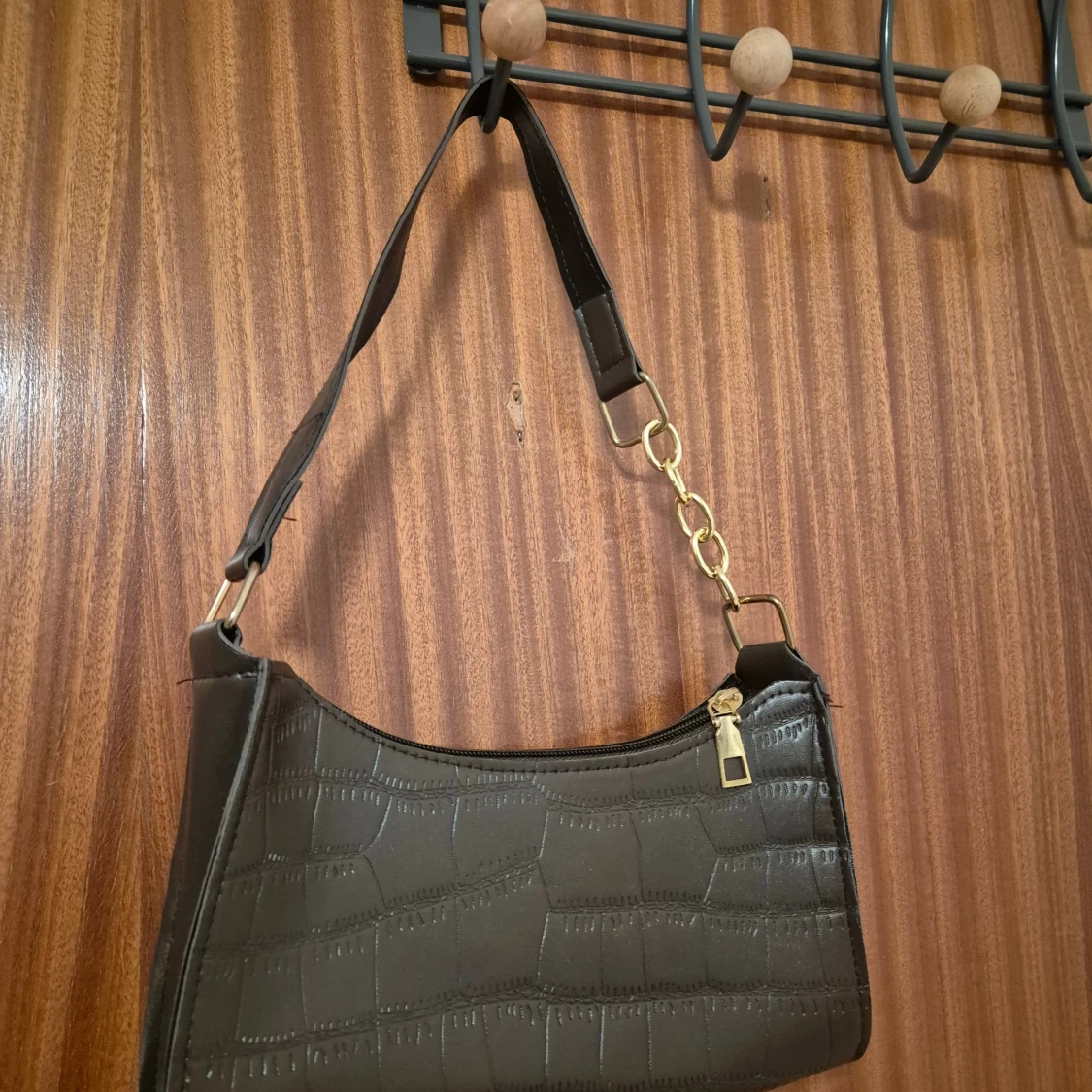 Mörkbrun väska med guldiga detaljer