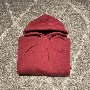 Superdry hoodie vinröd  - En riktig snygg vinröd Superdry hoodie i väldigt bra skick storlek M det är bara att skiva vid eventuella frågor