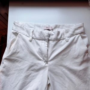 Vita kostymbyxor från Nelly, strl 32 - Snygga vita lalågmidjadekostymbyxor från Nelly i storlek 32.❤️ byxorna är andvända en gång eftersom de va lite för små❤️ ställ gärna frågor. Dock finns en lite svart fläck men den går nog bort i tvätten och syns knappt❤️🥰