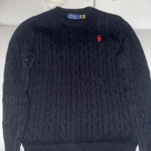 Svart kabelstickad tröja Polo Ralph Lauren - Kabelstickad svart Ralph lauren tröja som är i väldigt bra skick, har inte används så mycket. Storlek S men är liten i storleken så passar även xs. 