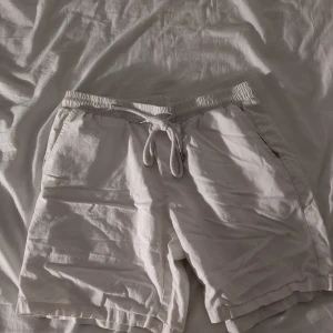 Beigea shorts med snörning - Snygga beigea shorts med elastisk midja och snörning framtill. De har två sidofickor och två bakfickor, perfekt för chill dagar. Materialet känns lätt och luftigt, vilket gör dem grymma för varma sommardagar.
