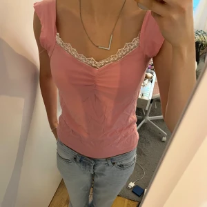 Rosa topp med spets och v-ringning - Har sytt den själv, men den sitter bra på mig, så jag skulle säga att den passar någon med storlek S bra men även XS.