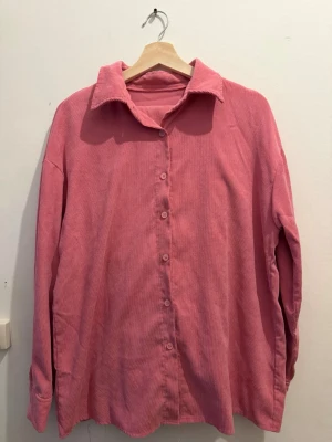 Rosa stilig skjorta  - Rosa skjorta i storlek M. Använd ett fåtal gånger och i mycket fint skick, helt utan skador eller fläckar. Stilren modell som passar både till vardag och mer uppklädda tillfällen. Lätt att matcha med både byxor och kjol.
