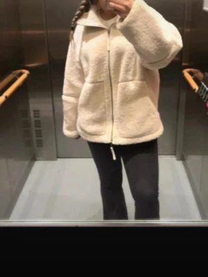 Beige teddyjacka Hm - Slutsåld populär teddyjacka från Hm. Jackan har hög krage, dragkedja framtill och stora fickor. Perfekt för kyliga dagar och ger en riktigt cozy vibe. Materialet är fluffigt och värmande, och modellen är loose för en avslappnad look. Storlek xs men passar xs,s, m