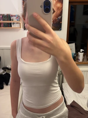 Vit linnetopp från OXXO - Säljer ett vitt linne med breda axelband och fyrkantig urringning. Linnet är tajt och har används ett fåtal gånger.