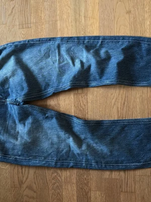 Slim fit jeans från Massimo Dutti - Snygga blå jeans från Massimo Dutti med slim fit-passform. Klassisk femficksdesign och raka ben. Jeansen är tillverkade i slitstarkt denimtyg och har en mörkblå tvätt med subtila skiftningar. Perfekt för dig som gillar en stilren och modern look. Passar dig som har jeans storlek 31/32