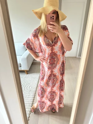 Strl 36 strandklänning bohemisk mönstrad cover up - Säljer en lång, boho strandklänning med v-ringning och korta ärmar. Perfekt för poolhäng och strandbad! 
