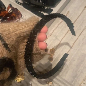 Svart diadem med glittriga pärlor - Snyggt svart diadem täckt med små glittriga pärlor som ger en lyxig känsla. Perfekt accessoar för att lyfta din look och hålla håret på plats. Diademet har en klassisk form och är bekvämt att bära hela dagen.