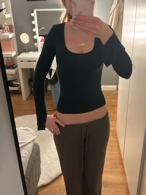 Mörkblå långärmad topp Gina Tricot XS - Säljer en mörkblå långärmad topp från Gina Tricot i storlek XS. Toppen har en djup rundad halsringning och är figurnära med slits vid ärmslut. Materialet är mjukt och stretchigt, perfekt för en clean och enkel look.