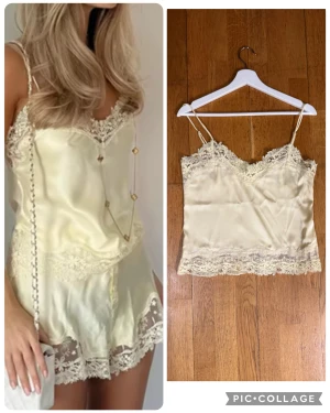 Champagnefärgad linnetopp med spets XS-S - Säljer en champagnefärgad linnetopp med tunna axelband och vacker spetsdetalj längs halsringning och nederkant. Toppen är gjord i glansigt satinliknande material som ger en lyxig känsla. Perfekt att styla med jeans eller kjol för en chic look.