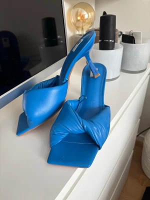 Blå pumps med låg klack och twistad rem - Säljer nu dessa blåa fina klackskorna som tyvärr inte kommer till användning så de är helt oanvända. Storleken är 40 men jag skulle mer säga att de är 38/39. Perfekta nu till sommaren☀️