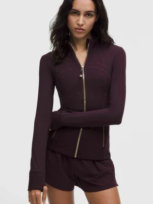 Mörklila träningsjacka med dragkedja - Snygg träningsjacka med guldiga dragkedjor och hög krage. Jackan har långa ärmar med tumhål och figurnära passform, perfekt för träning eller löpning. Materialet är stretchigt och andas bra.