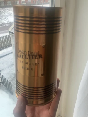 Jean Paul Gaultier Le Male Elixir - Jean Paul Gaultier Le Male Elixir parfym i en unik guldfärgad flaska formad som en manlig torso. Flaskan har en metallisk finish och levereras i en matchande guldfärgad cylinderförpackning med svarta detaljer. Perfekt för dig som gillar exklusiva och iögonfallande dofter.