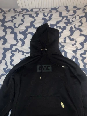 Svart UFC hoodie - Säljer en svart hoodie från UFC . Hoodien har en diskret UFC-logga på bröstet och en klassisk magficka framtill. 