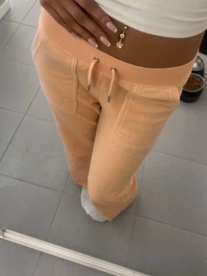 Juicy Couture byxor - Peachfärgade Juicy Couture byxor! super snygga, saknar dock en knapp på ena fickan (se bild 5)