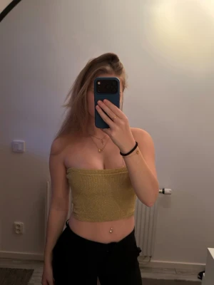 Guld ribbad croppad tubtopp - Trendig guld croppad tubtopp med ribbad struktur. Endast använd 1 gång.