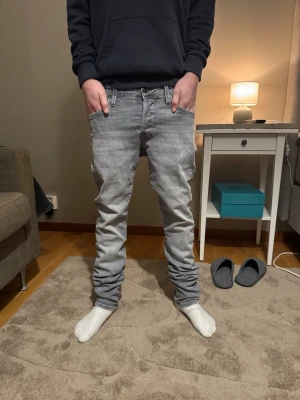 Gråa slim jeans från Jack&jones  - Säljer ett par gråa jj jeans i slim fit med klassisk femficksdesign och låg midja. Jeansen har raka ben och är tillverkade i mjukt bomullsmaterial med en snygg tvättad look. Perfekta för dig som gillar en avslappnad men stilren stil.