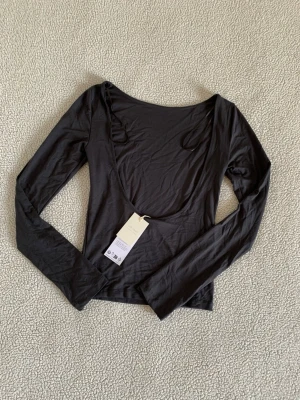 Ginatricot mörkgrå långärmad tröja med öppen rygg - Trendig grå långärmad topp från Ginatricot med öppen rygg i mjukt soft touch material. 